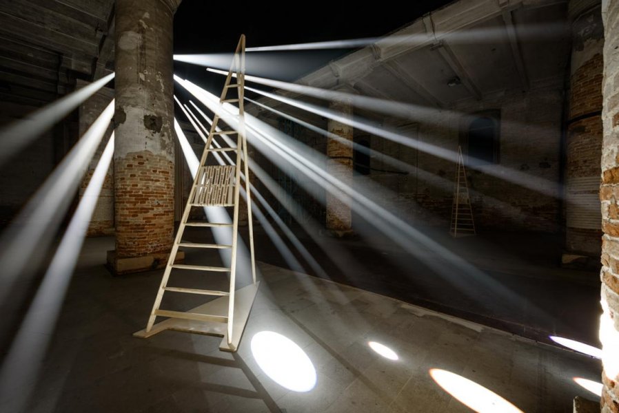 Rays of light hit the ground of a hall in which a ladder is standing